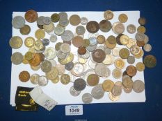 A tin of foreign and English coins including Winston Churchill Crown, American dollars, francs, etc.
