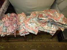 A pair of lined Curtains in a terracotta and muted blue floral pattern,