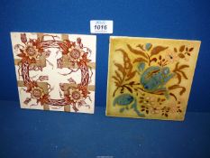Two decorative Tiles, brown and cream floral wreath and blue and pink floral.