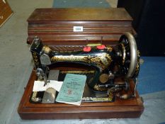 A cased Singer hand sewing machine no. 14670401, with instruction booklet.