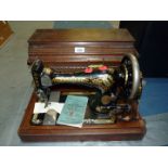 A cased Singer hand sewing machine no. 14670401, with instruction booklet.