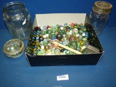 Two jars of old marbles in various sizes, some being opaque.