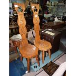 A pair of Oak Arts & Crafts Spinning Chairs having carved mirrored images of ladies in Crinoline