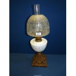 An Oil lamp having cast base, blue and white china reservoir and etched shade, plus chimney.