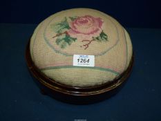 A tapestry topped circular footstool.