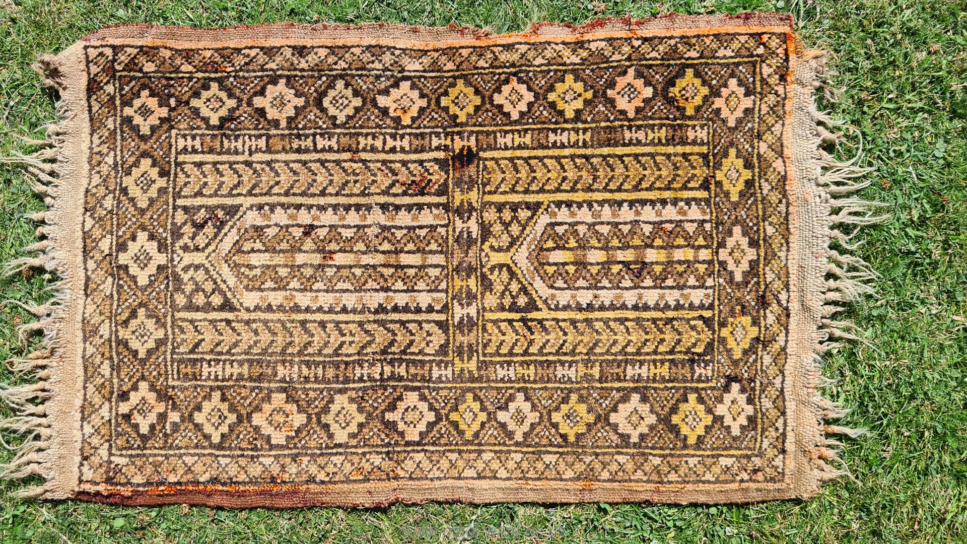 A faded natural dyed terracotta ground Islamic prayer rug, a/f., approx. 16 1/2" x 26".