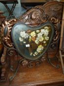 An Arts & Crafts wrought iron framed firescreen having bronzed details,