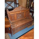 A medium Oak hall settle having a locker-base seat,