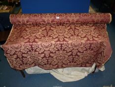 A large roll of floral burgundy ground upholstery fabric, 56" wide, approx. 8 - 10 metres.