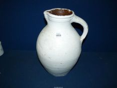 A painted terracotta jug with handle, 14" high.