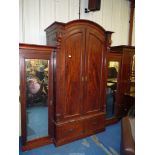 An imposing break-front Mahogany wardrobe the arched centre section having a pair of opposing doors