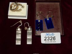 Three pairs of earrings: blue enamel droplet, a two toned bar droplet and silver hoops.