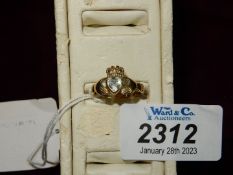 An 9ct Irish gold ring set with clear heart shaped stone between clasped hands and cross,