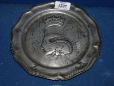 A Pewter display plate with a design of a Komodo style Dragon, crown and crosses, 8 1/2'' diameter.