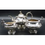 An ornate Silver three-piece Teaset profusely decorated in relief with scroll-work and trailing