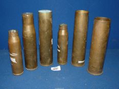 A quantity of smaller shell cases including 48 mm casing, 37 mm casing,