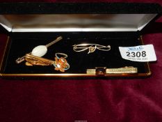Two tie pins, plus two stick pin brooches one with white stone, the other gold coloured wishbone.