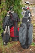 Three golf bags with clubs.