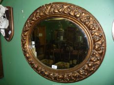 An oval Wall Mirror having a gilt and gesso frame, 25 3/4'' x 22'' approx overall, some losses.
