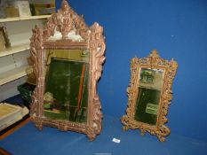 A small cast metal mirror with ornate scrolling, 18" x 11",