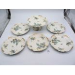 Five Limoges plates and fruit stand decorated with blue flowers and gilt to the edges,