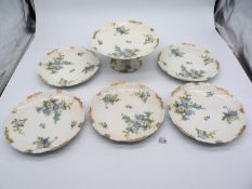 Five Limoges plates and fruit stand decorated with blue flowers and gilt to the edges,