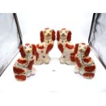 Two very good pairs of mid-19th century Staffordshire mantle spaniels painted in red with gilt