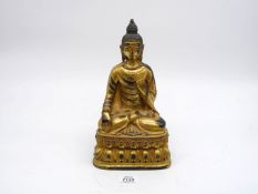 A large Sino-Tibetan gilt bronze figure of a meditative buddha in the 15th century style, c. 1900.