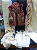 A quantity of vintage garments to include an embroidered tunic/dress, white overcoat, shirt,