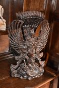 A magnificently carved Burmese hardwood ornament depicting a female figure on the shoulder of a