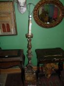 An carved wood and gesso floor standing Lamp with signs of formerly being gilded,