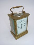 A brass cased bevelled glass Carriage Clock having an enamelled face with black Roman numerals and