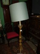 A giltwood Floor Lamp having a lobed urn base raised on a triple paw footed plinth and with a