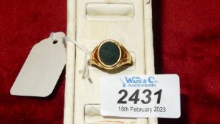 An 18 ct Gold Ring with a dark polished oval stone, total weight 5.5 gms.