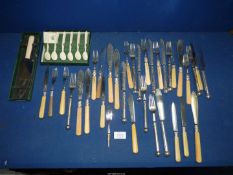 A quantity of plated knives and forks, some with bone handles.