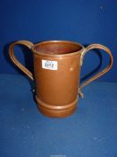 A large copper two handled mug with a small lizard to the base of the interior, 7 3/4" tall.