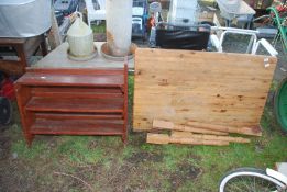 A Pine table, 4' long x 30" wide approx and a shelf unit, and a wooden folding chair.