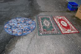 Three carpets including circular floral, green and red hearth rug, etc.