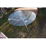 A circular glass topped patio table, 30'' high, x 35 1/2'' diameter.