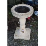 A concrete bird bath, 25'' high overall x 16'' diameter.