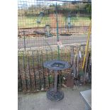 A hanging bird feeder and a plastic bird bath.