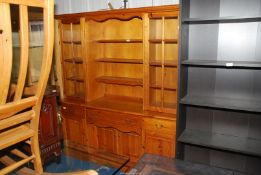 A contemporary Pine dresser, the base having frieze drawers with cupboards below, and shelves above,