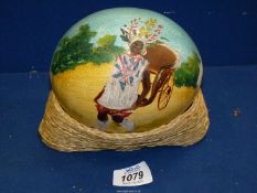 A painted Ostrich Egg featuring a Lady pulling cart.