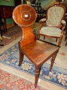 A Mahogany solid seated Hall Chair having turned front legs and oval feature backrest.