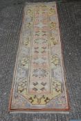 A pink and yellow ground Runner with geometric pattern, fringed, slightly faded,