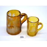 Two amber glass Tankards, the smaller one being Waisbaden, the larger one a/f.