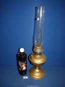 A Victorian brass Aladdin oil lamp with glass chimney and bottle of lamp oil, 23 1/2" tall.