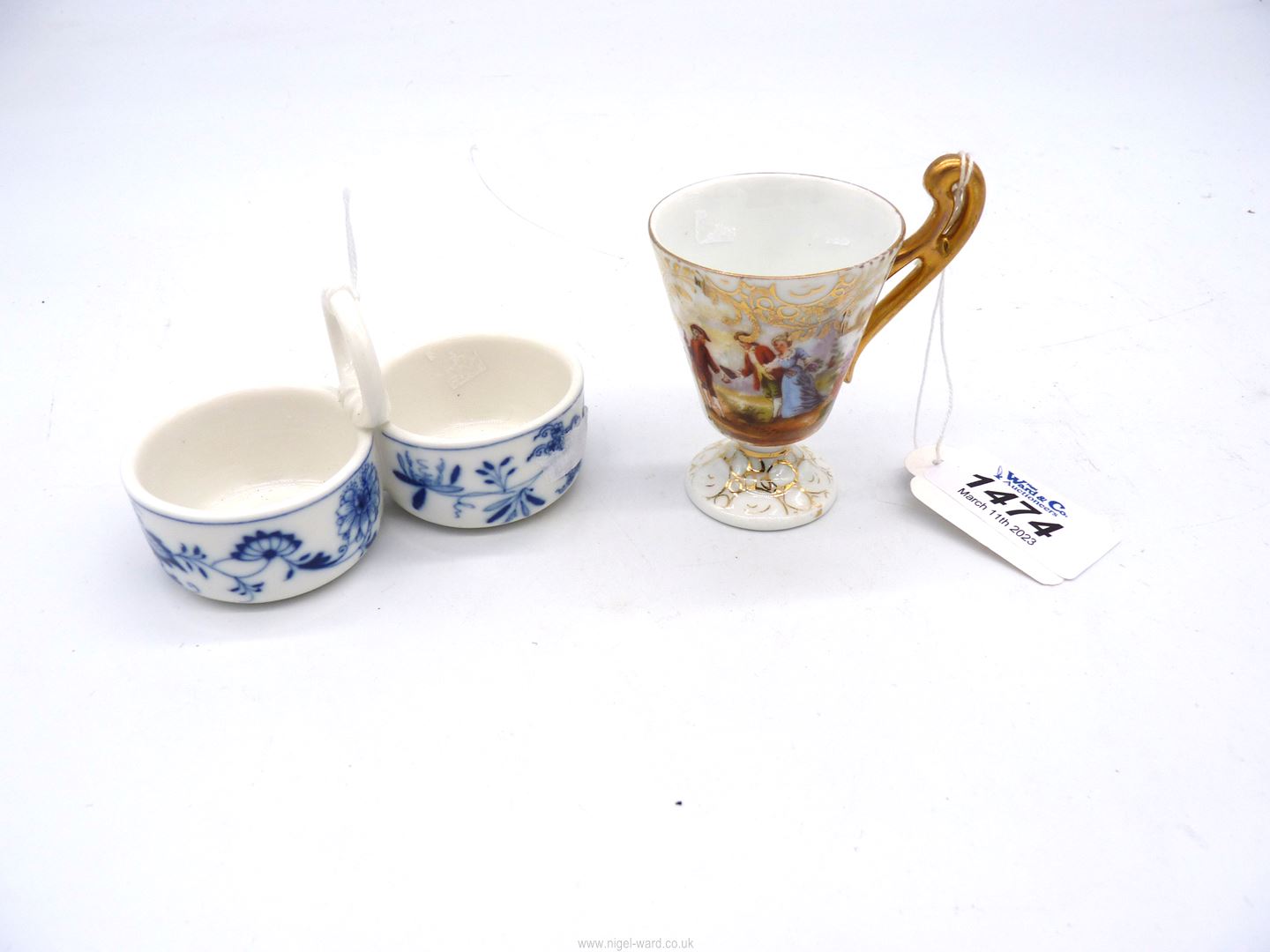 A pretty Meissen blue and white floral salt and pepper pots plus a continental miniature cup with