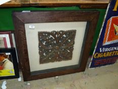 A floral carved wooden panel (14'' x 13'') in a thick wooden framed glass case, 27 1/2" square.