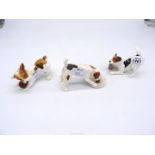 Three Royal Doulton figures of Jack Russell puppies, one chewing a slipper,